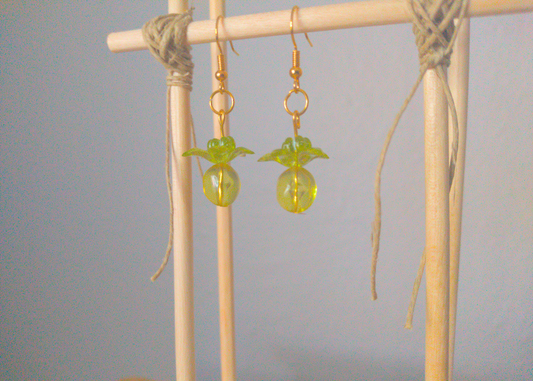 A front facing image of a pair of green handmade earrings being displayed on a stand. There are three stacked beads that make up the earring. The first bead is a small green flower. The next bead is a larger green flower and the last is a large ball.  All beads are translucent. The hooks are a golden color.