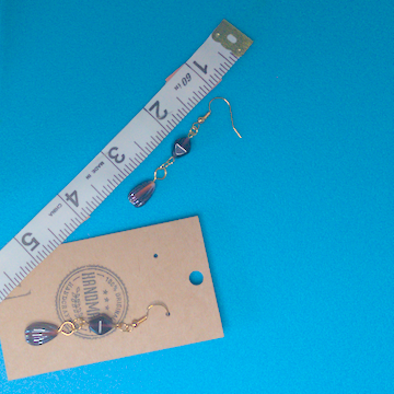 A pair of brown earrings being measured on a work table. The pair is 2.25 inches long.